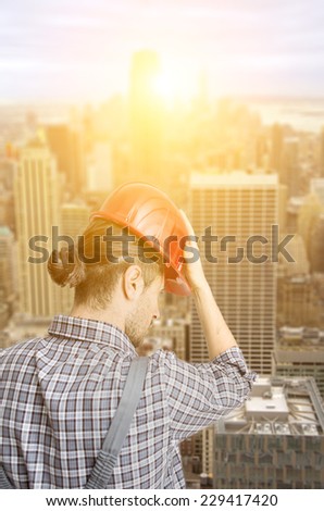 New York City skyline aerial view. worker with helmet watching the town from his place of work on a building roof