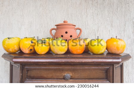 kaki fruits on a antique piece of furniture. vintage concept about autumn