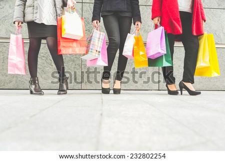 Women with high heels and shopping bags - Three girls standing and chatting after buying presents