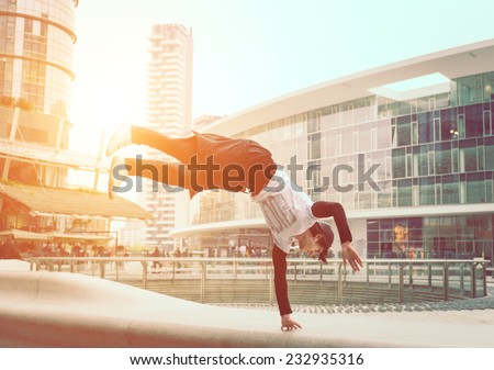 extreme parkour in business center. young boy performing some jumps from parkour discipline