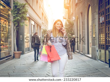 young woman making shopping in the center of milan and talking to the phone