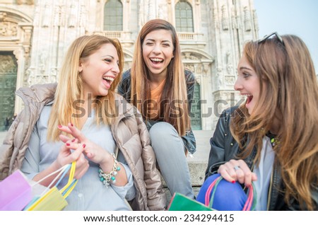 Group of attractive young women sitting on stairs and smiling and laughing - Three students sitting outside university - Best friends spending time together