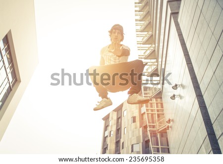young boy making an high jump while performing parkour