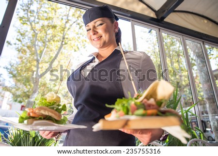 waitress bringing two piadinas at table. concept about service and food