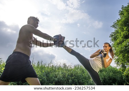 Woman training  self defense martial arts with coach - Martial arts athlete kicks