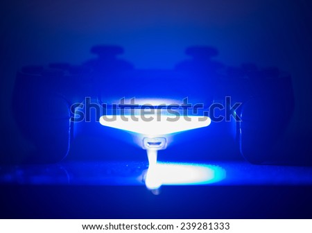 video game controller in blue light. concept about home entertainment