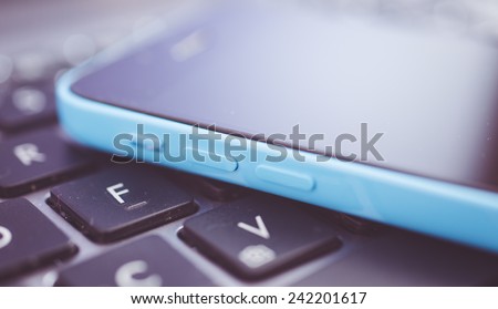 new generation smart phone lying on the computer keyboard