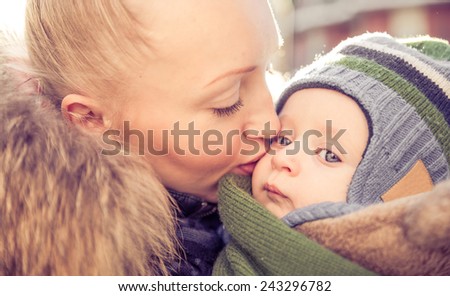Mom kissing her handsome son - Woman and baby outdoors