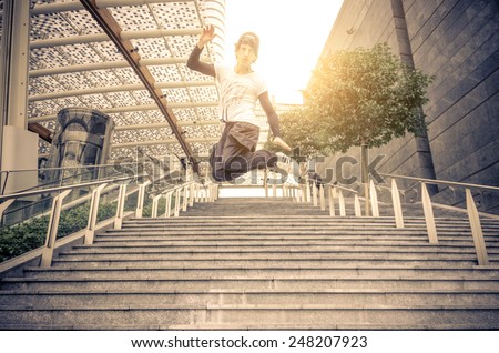 Young athlete performing parkour tricks - Free runner jumping a stairway