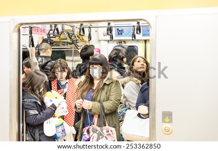 TOKYO,JAPAN - FEBRUARY 10,2015: people in a subway train wagon. The transit system carries almost an average of 8 million passengers daily.