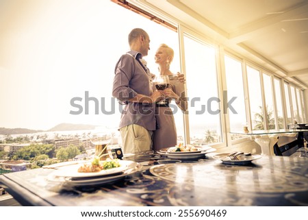 Beautiful happy couple having romantic dinner at sunset in a luxury restaurant - Woman and her husband celebrating wedding anniversary
