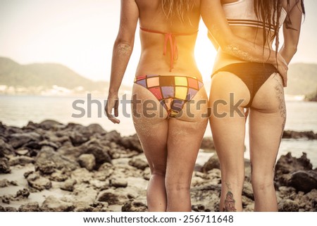 two girls hugging on the side and watching sunset at paradise beach, Phuket.