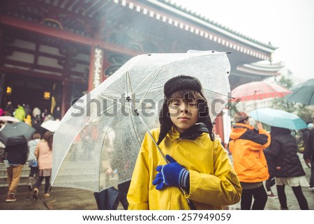 little japanese boy in  Asakusa temple during a rainy day