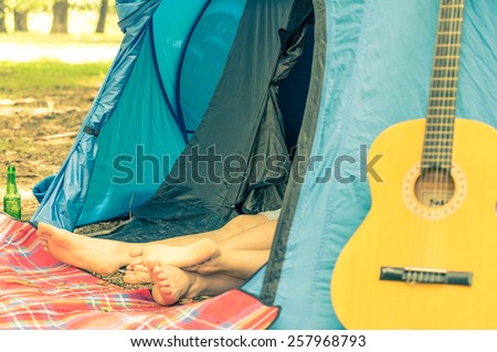 Couple sleeping in a camping tent after a night of party