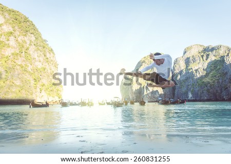 man performing high flying kick at maya beach, thailand