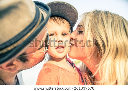 Mom and dad kissing their handsome son - Family and baby outdoors