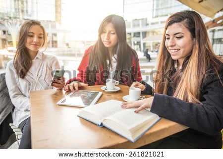 Group of friends at restaurant drinking coffee - Women with books,tablets and smart phone - Concepts about technology,communication and youth culture