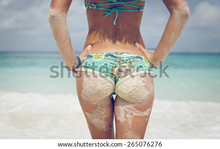 woman buttock dirty with sand with beautiful clear water background. concept about vacations, body care, summer, nature and people