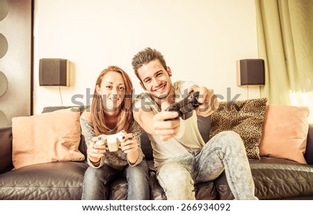 couple playing video games on the couch. concept about home entertainment, people and couple