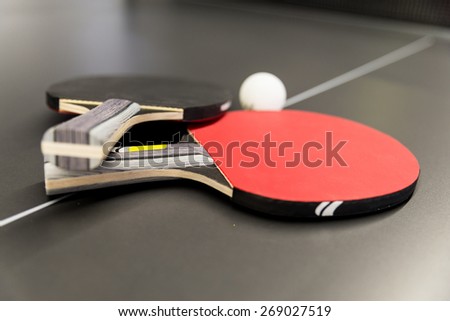 Ping pong rackets and ball on black table tennis