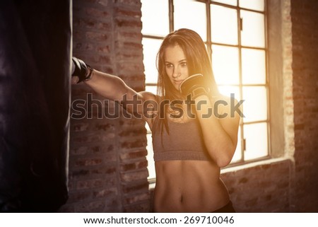 young woman training on the heavy bag the jab. concept about sport, fitness, martial arts and people