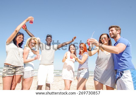 Group of friends having party on the beach - Some people drinking and dancing in a bar outdoors -Young playful people having fun and toasting drinks to celebrate