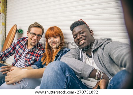 Group of friends of different ethnics taking a selfie - Young modern hipster people having fun and laughing - Multiracial group photographing themselves and looking into camera