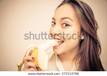 biting the banana. woman eating a banana for breakfast. concept about food