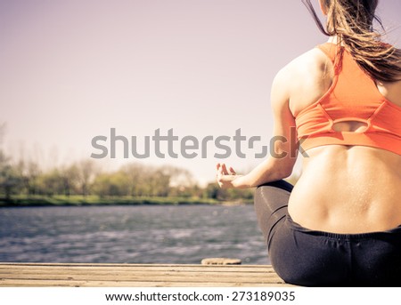 yoga in the nature. woman making yoga exercises in front of the lake. concept about relaxation, meditation, fitness and people