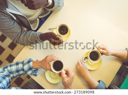 coffee break. three friends sitting and having a coffee in a store. concept about people, coffee, and bars