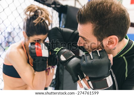 mma training. couple making sparring in the mma cage. concept about fighting, fitness and sport