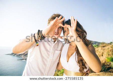 Couple in love making a heart shape with hands - Lovers on a romantic date outdoors - Concepts about love,wedding,relationship