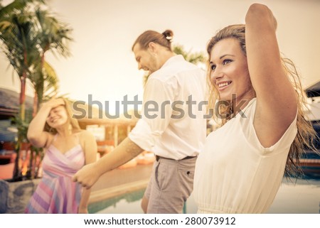 Friends at party dancing in a open air club - Three happy and smiling persons having fun and listening music at a private party