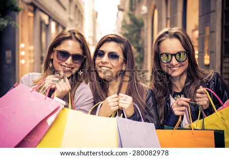 smiling girls with shopping bags. three friends making shopping in the city center