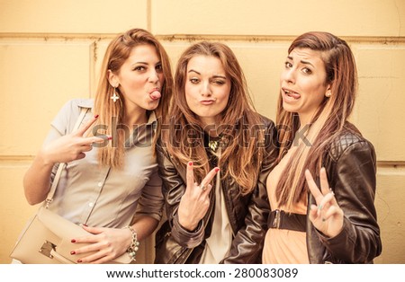 three happy girls making funny faces. concept about friendship and people