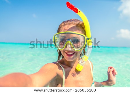 Young beautiful girl with diving mask taking a selfie on a tropical island - Tourist having fun diving in crystalline blue water - Happy tourist on vacation