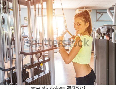 woman training in the gym. she is making triceps at the pull machine. concept about fitness and wellness