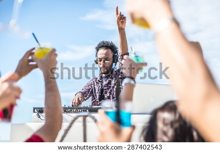 dj set at the beach party. dj spins the music and people is excited with hands up. concept about party, music and people