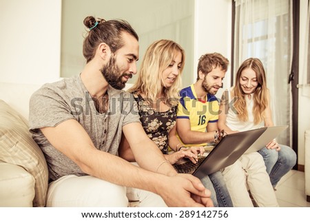 four friends studying with laptop on the couch. concept about students, education and technology
