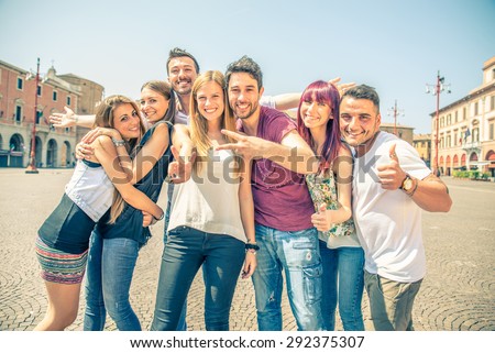 Group of friends grimacing in front of the camera - Young happy people having fun outdoors and posing for the camera