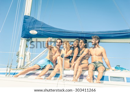 Group of friends on a boat taking a selfie - Multiethnic people having fun and partying on a sail boat - Tourists on a summer vacation