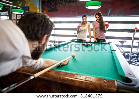 Two couples having fun at billiard - Group of multiracial young people standing next to pool table and holding cue - Students spending an evening at pub
