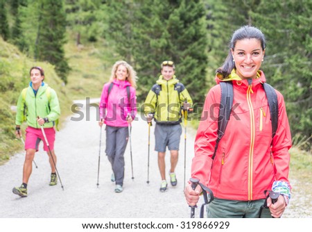 group of friends making trekking excursion in the forest. concept about seasonal leisure activity,nature, and people