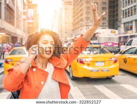 afro american woman calling a taxi in New York near Time square district. concept about urban life, people and transportation