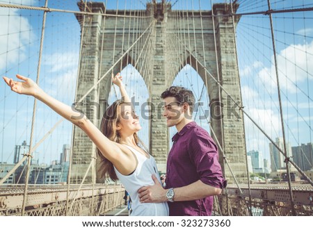 happy couple hugging each other on the famous brooklyn bridge. concept about love,travel and people