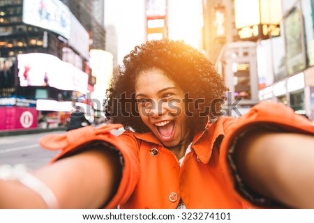 afro american woman taking selfie in Time square, New york. crazy portrait in the famous american square