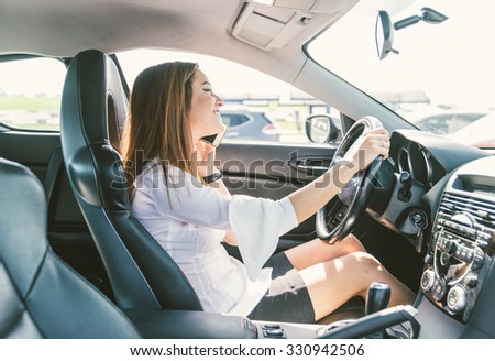 Woman talking on the phone while driving the car. Concept about dangerous behavior while driving a vehicle