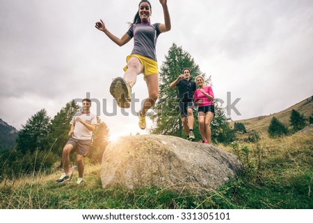 Runners training on a off road track - Group of hikers walking in the nature at sunset - Friends taking an excursion on a mountain