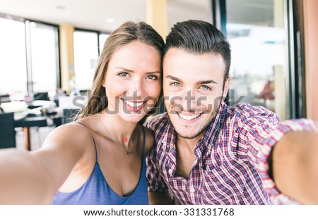 Couple taking self portrait with smart phone. Beautiful young couple selfie