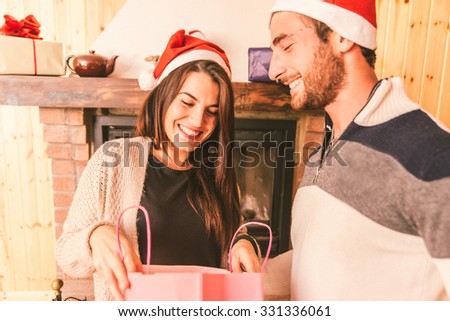 Young couple sharing christmas presents in their house. concept about love,holidays and christmas